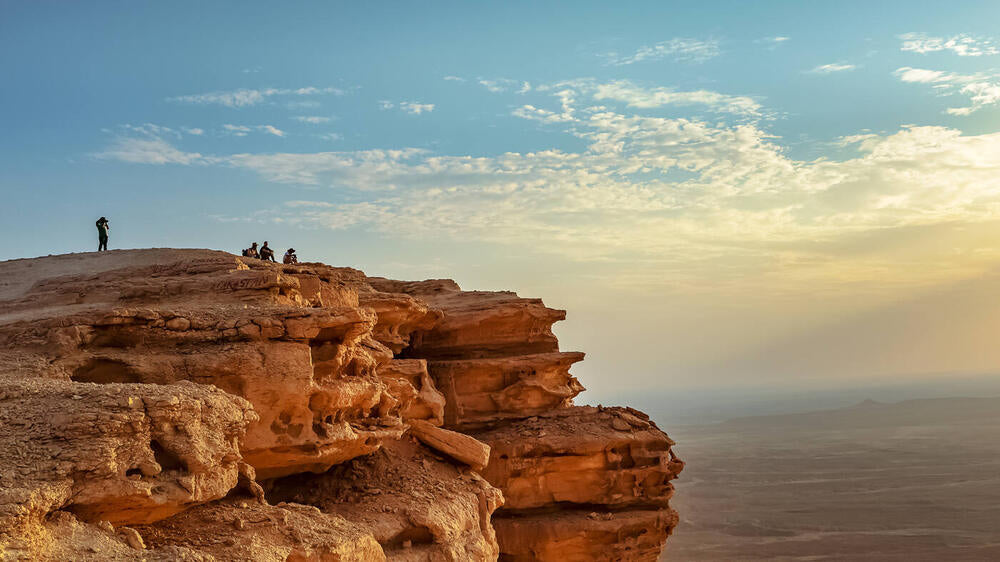 Source photograph: a red rock cliff edge against the sky.