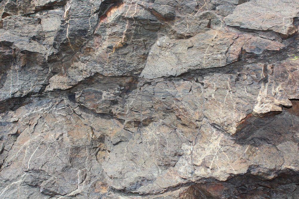 Source photograph: a cracked granite rock face.