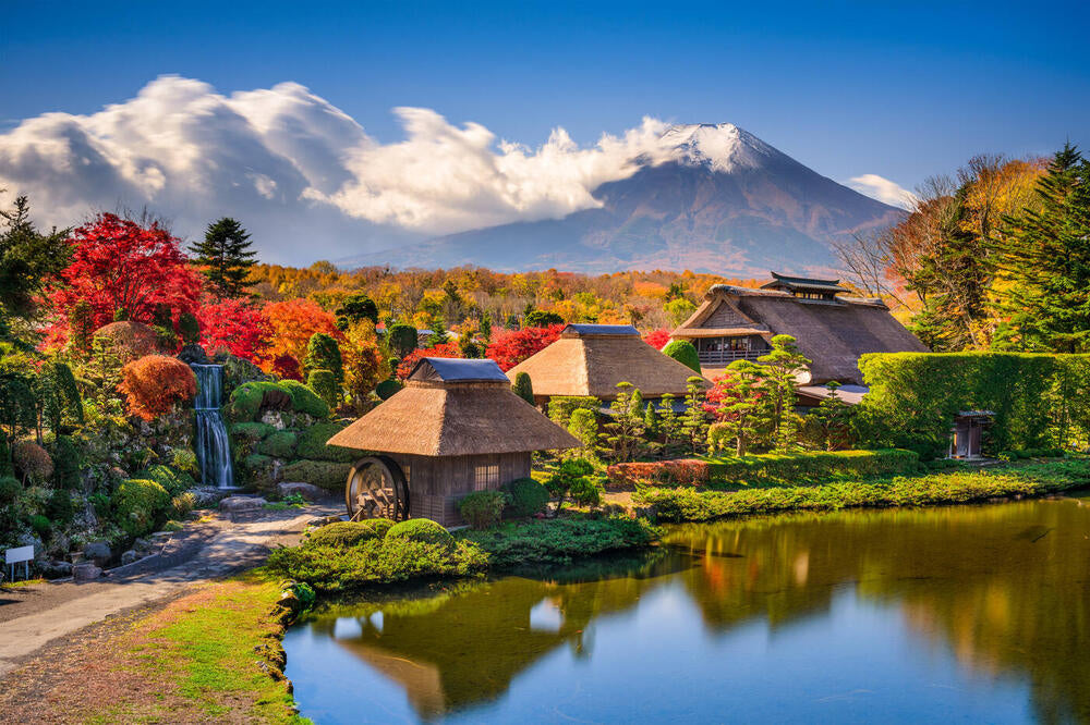 Source photograph: thatched houses beside water with autumn trees and a mountain.